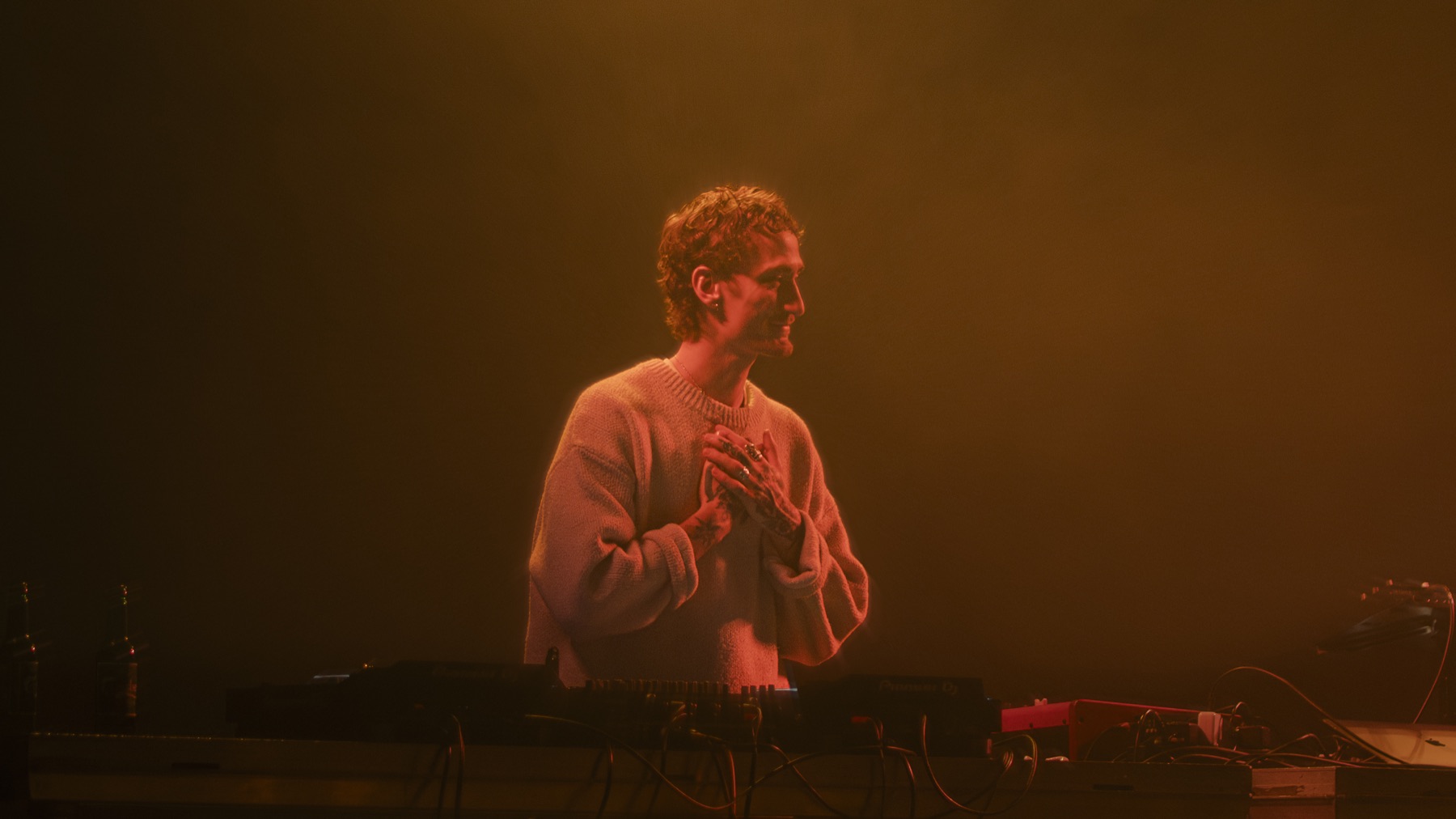 Liam Berg performing electronic music under violet stage lighting